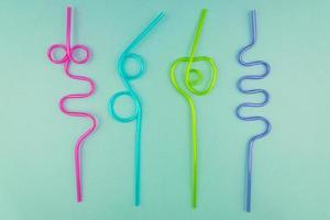 multicolored plastic cocktails straws on blue background photo