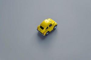 Flat lay in a trendy 2021 new colors. Illuminating Yellow and Ultimate Gray. Color of the Year 2021. Retro toy car on grey background with copy sapce photo