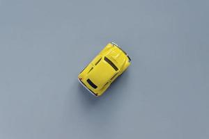 Flat lay in a trendy 2021 new colors. Illuminating Yellow and Ultimate Gray. Color of the Year 2021. Retro toy car on grey background with copy sapce photo