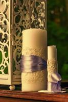 dos velas blancas con cintas moradas en el fondo de las velas foto