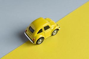 Flat lay in a trendy 2021 new colors. Illuminating Yellow and Ultimate Gray. Color of the Year 2021. Retro toy car on grey background with copy sapce. photo