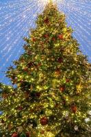 cerca de la decoración del árbol de navidad con adornos y guirnaldas. tarjeta de felicitación festiva para las vacaciones de invierno. foto