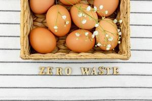 Zero waste concept. No plastic concept. Minimal style. Beige water hyacinth box with brown chicken eggs on textile background. Zero vaste wooden text photo