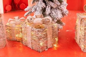 Christmas gifts made of metal and led light garland on red pedestal.Festive street decoration photo