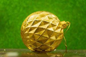 golden christmas bauble on green sparkling background photo