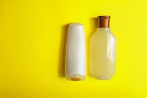 Set of White Cosmetic containers on yellow background, top view with copy space. Group of plastic bodycare bottles with empty space for you design photo