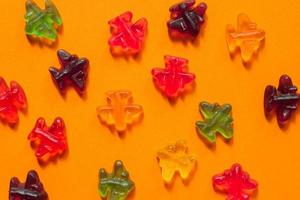 Jelly sweets, colorful marmalade airplanes on oarange background. Open pattern photo