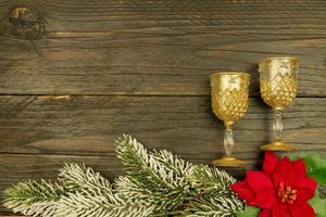 Happy New year 2021 celebration.Champagne glasses and poinsettia on wooden background. Flat lay. photo