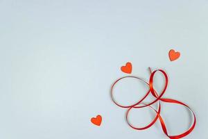 Red sequins heart with satin ribbon on blue background. Creative minimal layout with copy space for St Valentine Day. photo