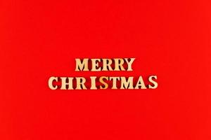 wooden letters on red background. Merry christmas lettering in red paper. Copy space photo