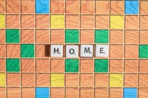 Scrabble game letters. Word home on game board. flat lay top view. photo