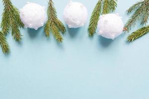 Christmas minimal concept - Christmas composition with fir branches and white baubles. Horizontal frame, flat lay, view from above. Pastel blue background with copy space photo