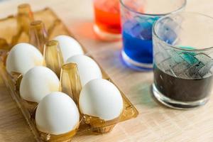 Easter Egg Dying Process. glasses with multicolored coloring water. Step of painting process. photo