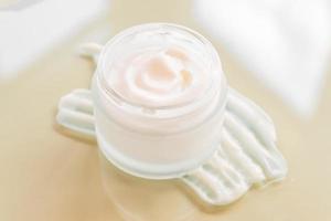 trazos de crema cosmética blanca sobre fondo beige. frotis de suero facial de loción para el cuidado de la piel. textura de producto de belleza. tarro blanco de crema facial o corporal. foto