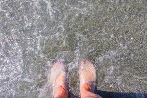 Female feet in protective rubber slippers for walking on corals. Top view photo