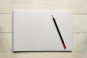red pencil on blank white album paper. Top view. school and office supplies. Copy space. photo