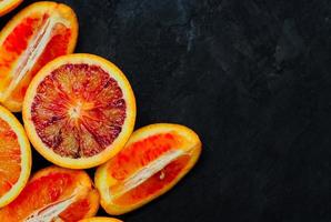 red oranges, delicious orange fruits, cut into halves and quarters for desserts preparation. photo