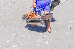 Beach vendor selling smoked fish and sea foods to tourists photo