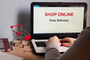 Shop online on Laptop Screen. Free delivery. E-commerce concept. Caucasian woman shop online from her home. photo