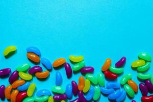 Assorted Jelly Beans border with copyspace on blue background. photo
