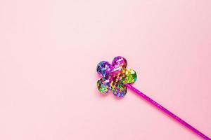 pink flower made of round sequins on pink background. Fashion party accessories with copy space. Festive flat lay. Minimal style. photo