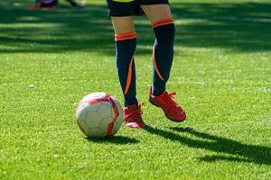 adolescente pateando la pelota en un campo. sesión de entrenamiento de fútbol juvenil. fondo de educación de fútbol con espacio de copia foto