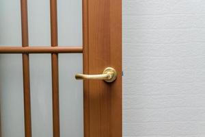 close up of room door and golden lock against white brick background. Interior design photo