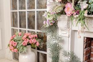 elegante diseño interior de la sala de estar con flores artificiales y chimenea. foto