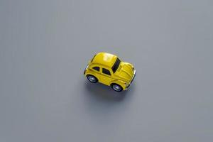 Flat lay in a trendy 2021 new colors. Illuminating Yellow and Ultimate Gray. Color of the Year 2021. Retro toy car on grey background with copy sapce photo