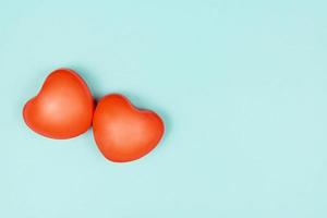 Valentine's day concept with two red hearts on light blue background, top view, copy space. Creative flat lay photo