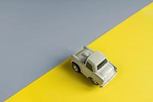 Flat lay in a trendy 2021 new colors. Illuminating Yellow and Ultimate Gray. Color of the Year 2021. Retro toy car on grey background with copy sapce photo