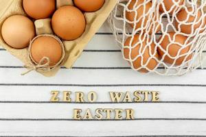 Zero waste Easter concept. No plastic bag concept. Minimal style. Beige mesh shopping bag with brown chicken eggs on textile background. photo