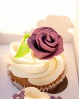 Closeup of tasty homemade cupcakes with sugar icing in paper box photo