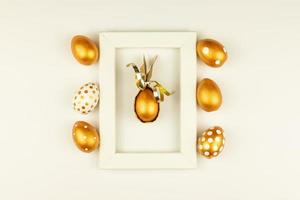 Easter festive decoration. Top view of easter eggs colored with golden paint and empty mock-up photo frame. Various dotted designs. White background.