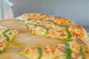 italian vegetarian focaccia with pesto on a wooen plate. Pizza with cheese photo