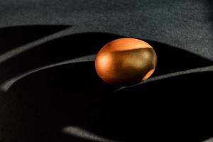 Golden egg on black background . A symbol of making money and luxury life. copy space photo