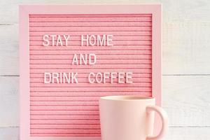 Pink Coffee cup and qoute Stay home and drink coffee. Self isolation and quarantine campaign to protect yourself and save lives photo