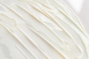 Close-up texture of white moisturizing cream. Skin care product background. Sun protection or liquid foundation. photo