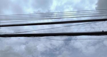 messy electricity wires on the pole, straight line of cables and wires on an electric pole in Thailand photo