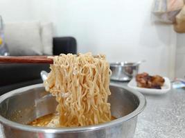 Bowl of instant noodles. Chopsticks. The food of the salaryman who struggles with the expensive cost of living photo