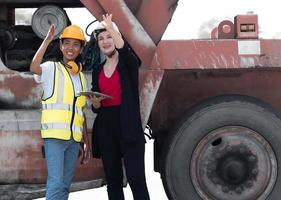 Diverse group of people working together at container terminal. Female African American foreman and industrial engineer woman manager standing at container depot. Diversity business people concept. photo