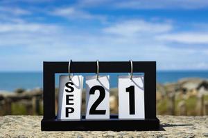 Sep 21 calendar date text on wooden frame with blurred background of ocean. photo