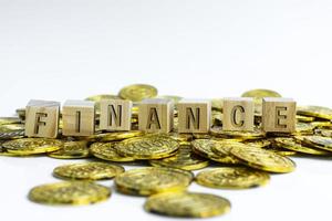 Financetext on wood block with a pile of gold coins. Business concept. photo