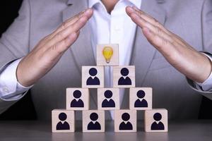 Human resources and corporate hierarchy concept, recruiter team consists of one leader, CEO represented by golden light bulb and icons. photo