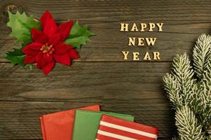 Happy New year 2021 celebration. Wooden text and poinsettia on wooden background. Flat lay. photo