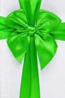 Green ribbon with bow as gift on white background photo