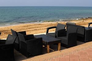 A chair in a city park on the seashore. photo