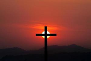 Silhouette of cross over sunset background photo