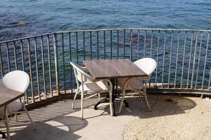 A chair in a city park on the seashore. photo