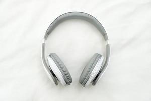 Bluetooth headphones on white fabric background photo